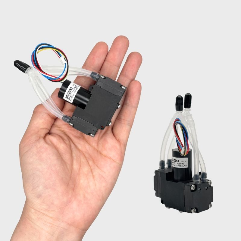 Compact 5V micro vacuum and pressure pump BD-05T01.52000B held in hand, ideal for portable OEM medical and therapy devices.