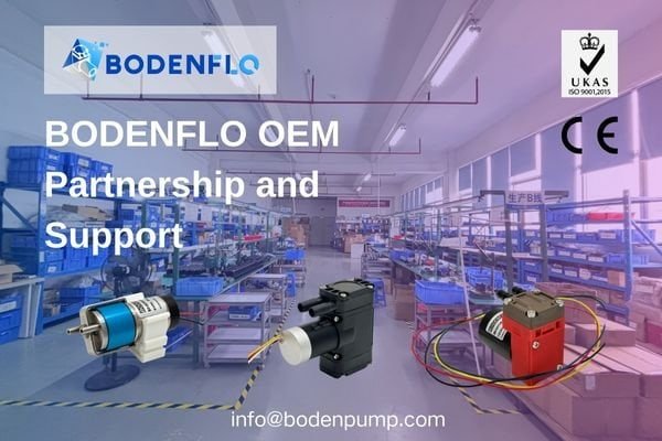 An image of a BODENFLO engineer working collaboratively with an OEM customer, looking at data on a screen with a particle counter and pump on the test bench.